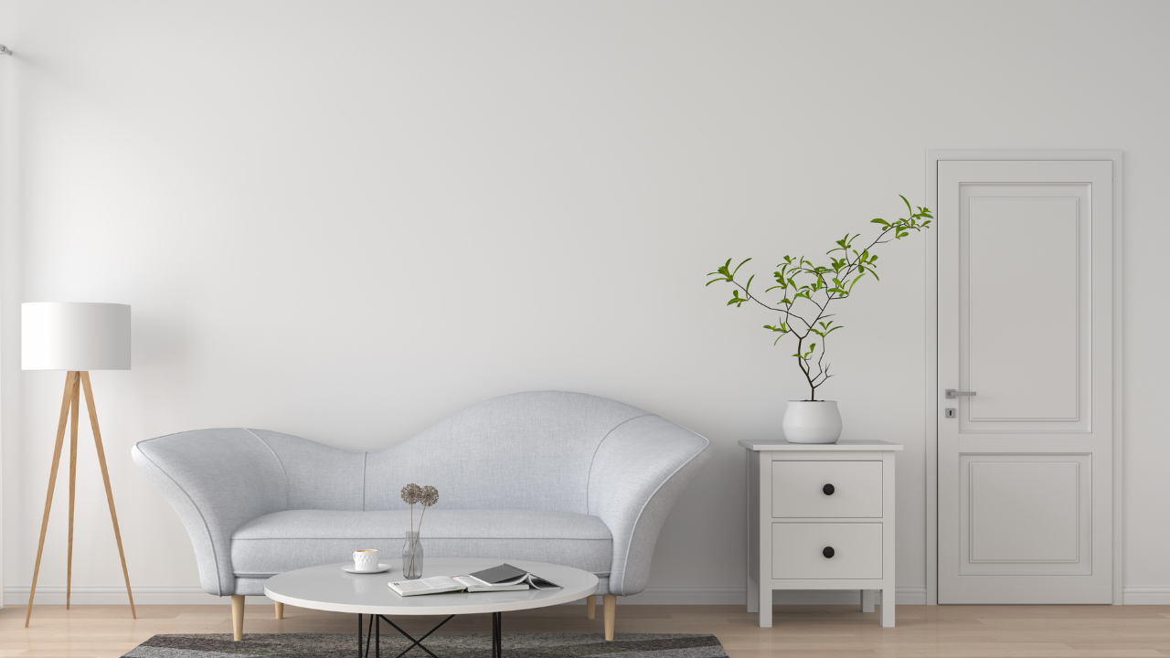 白とグレーを基調としたミニマルな部屋のインテリア。観葉植物と自然光が差し込む、整った暮らしの象徴的な空間。